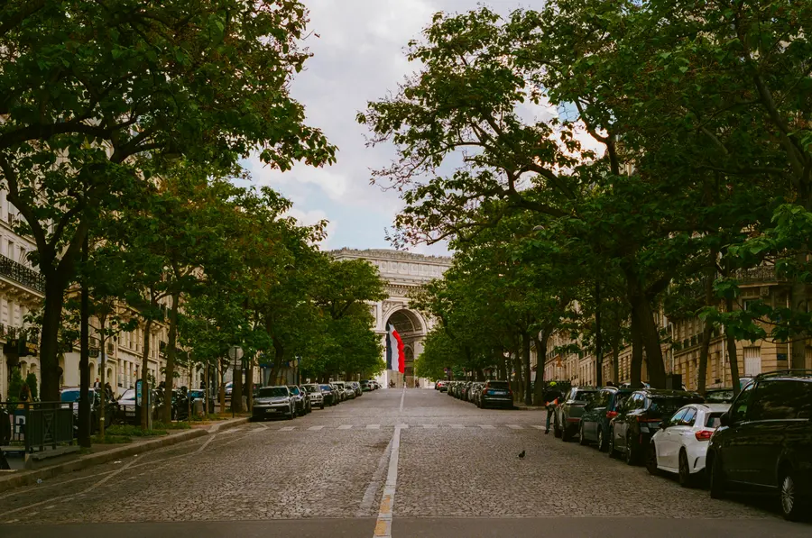 L'avenue vide — Une avenue plantée qui monte vers l'Arc, un dimanche matin. Presque personne.