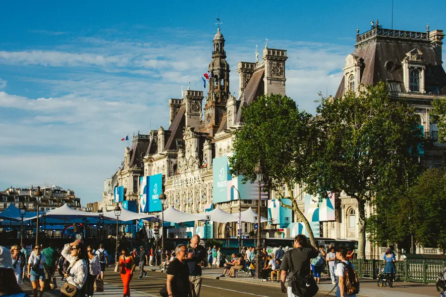L'Hôtel de Ville — La façade pavoisée, les terrasses pleines, un mercredi de juillet à midi.