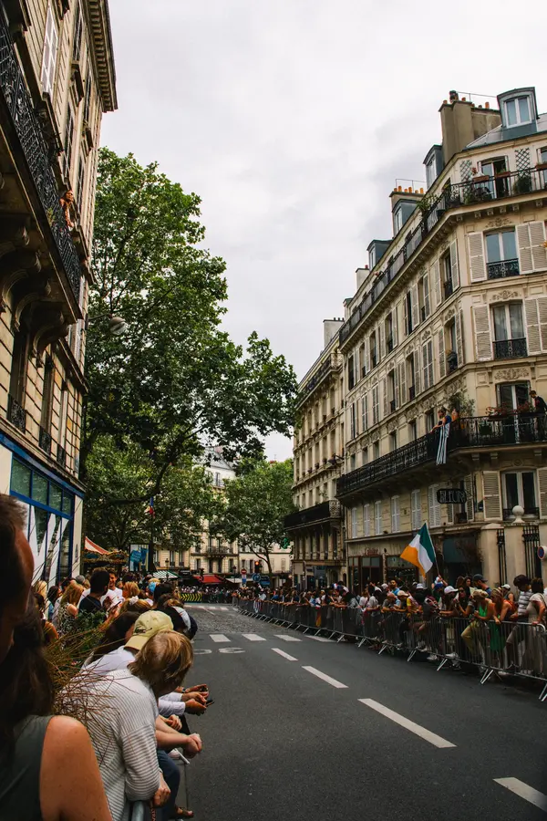 La rue attend — Une rue barrée, du monde aux fenêtres, et rien qui ne passe encore.