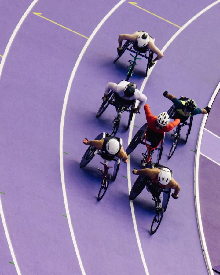 Le virage, en fauteuil — Cinq fauteuils dans la corde, vus du haut des tribunes. Le violet occupe tout le