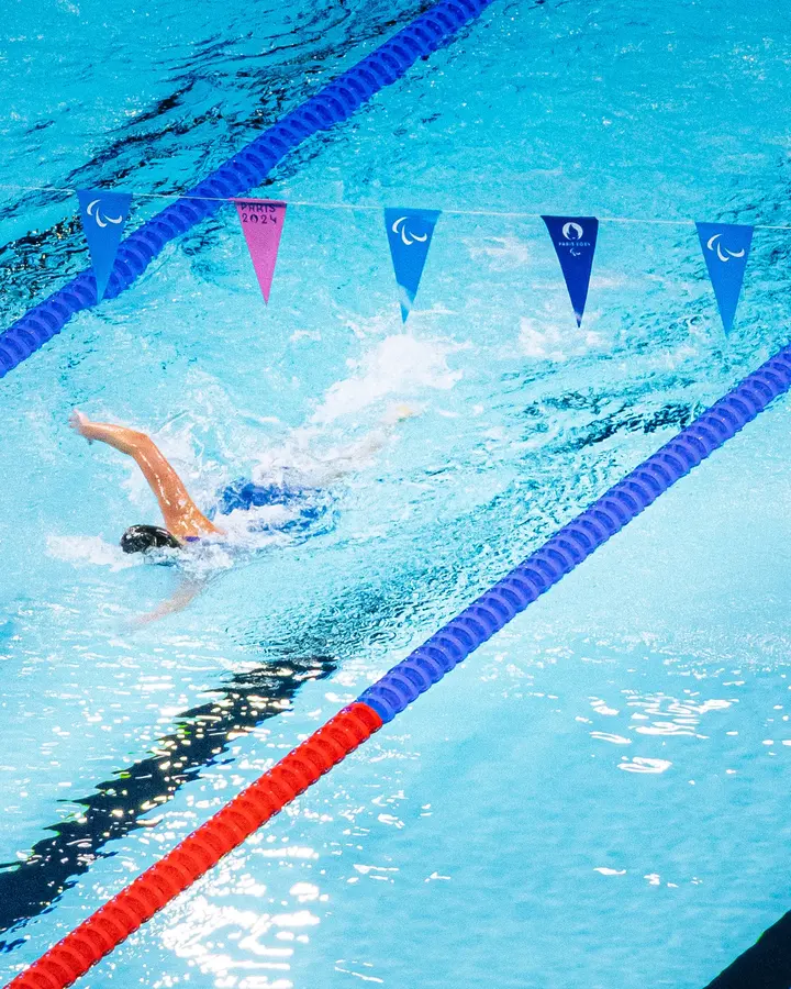 La ligne — Une nageuse, une ligne d'eau rouge et bleue, et du bleu partout ailleurs.