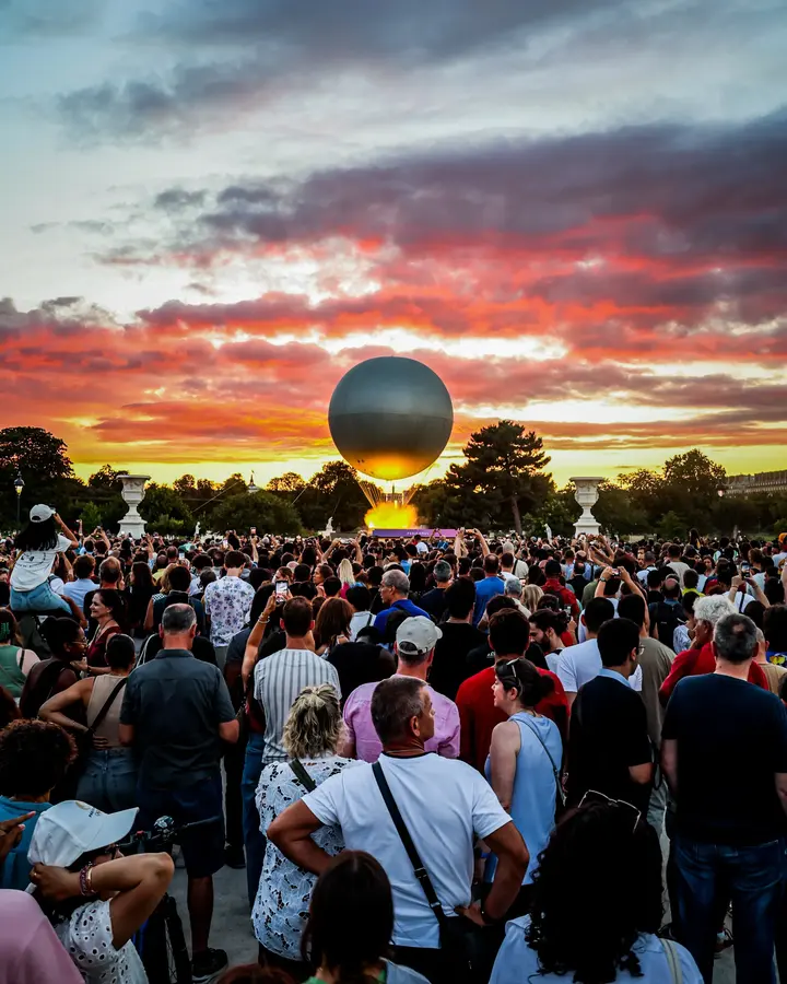 La vasque et la foule — Le ballon s'élève au-dessus des Tuileries, et deux mille téléphones se lèvent av