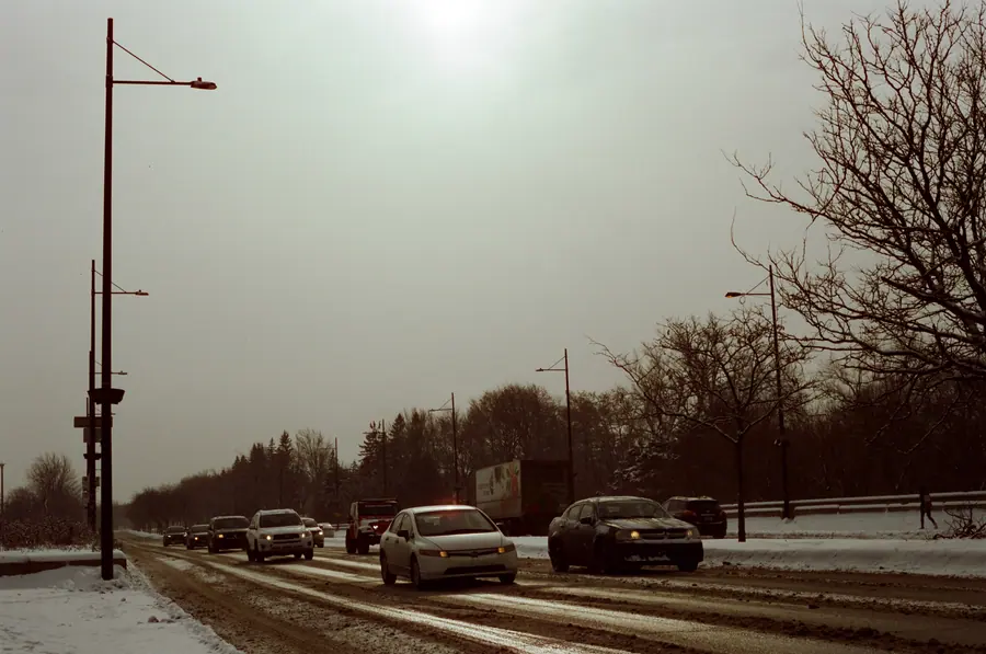 Route blanche — Le soleil n'est plus qu'un disque derrière la brume. La route file vers un point