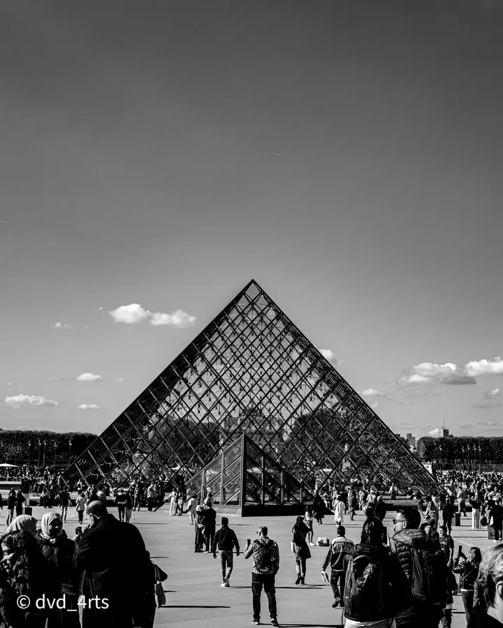 La pyramide, plein jour — Le triangle, la foule, un ciel vide. Le contraste fait le reste.