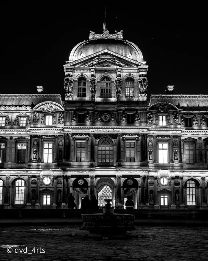 Le Louvre, la nuit — La façade allumée et sa fontaine, à une heure où la cour est vide.