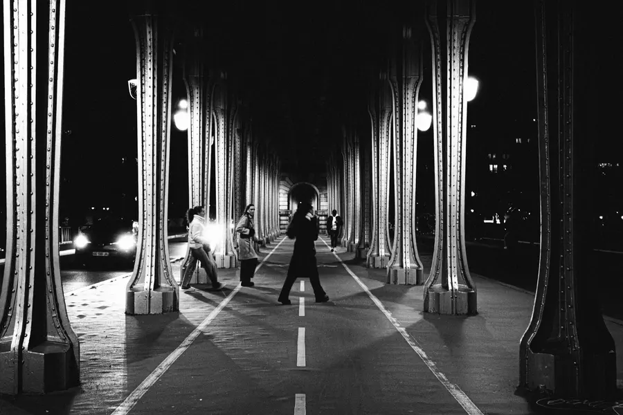 Bir-Hakeim, passants — Sous le viaduc, quatre silhouettes traversent la chaussée.