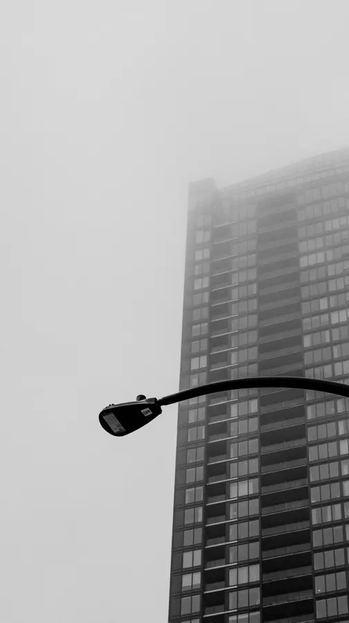 Brouillard I — Une tour s'efface dans le brouillard. Un lampadaire au premier plan donne le seu
