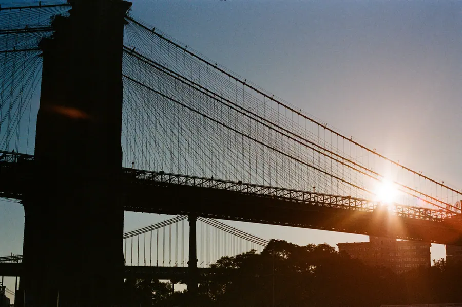 Contre-jour sur le pont — Le soleil se glisse entre les câbles du pont de Brooklyn et éclate en étoile. To