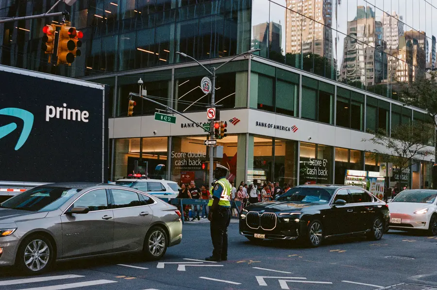 L'agent de la circulation — Un carrefour de Midtown bloqué, un agent en gilet jaune au milieu des voitures. 